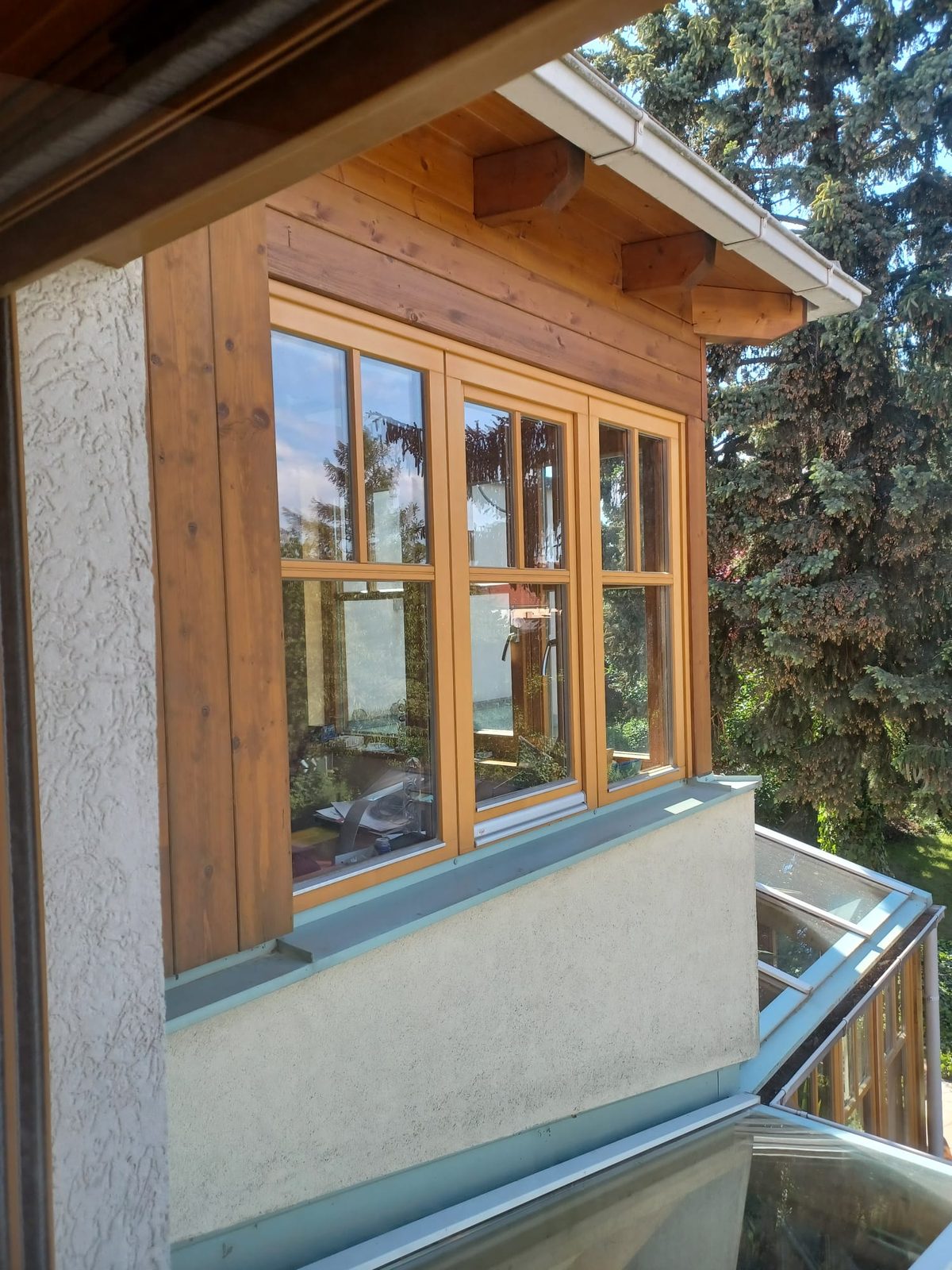 Holzfenster über Eck an einem Holzerker